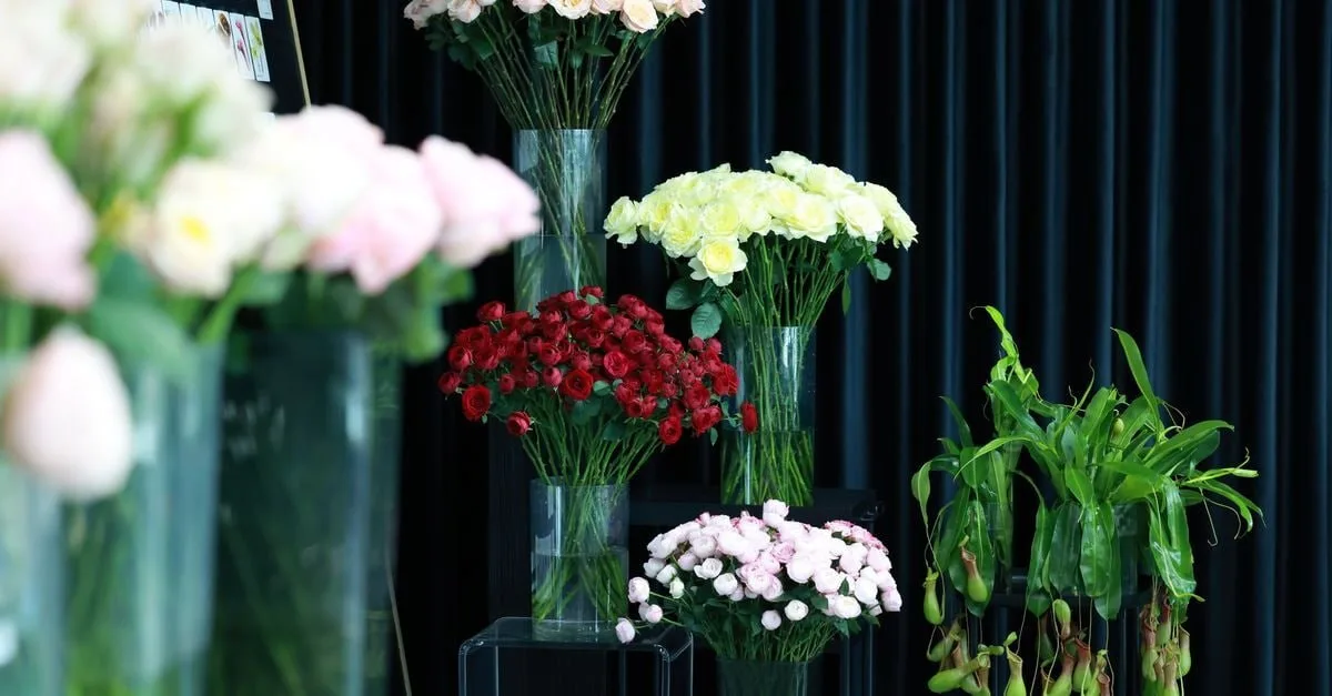 Fresh roses and tropical plants displayed in tall glass vases